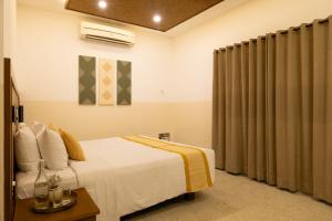 a hotel room with a bed and curtains at Hanu Reddy Residences, Poes Garden - Boutique Urban Retreat in Chennai +56 photos