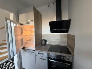 a small kitchen with a stove and a refrigerator at Moderne Ferienwohnung über 2 Etagen in Bissendorf