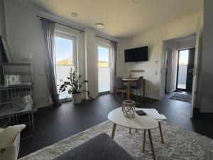 a living room with a couch and a table at Moderne Ferienwohnung über 2 Etagen in Bissendorf