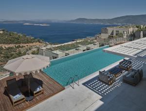 a swimming pool with chairs and an umbrella at WAM by Karma in Bodrum City