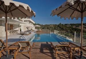 a villa with a swimming pool with chairs and umbrellas at WAM by Karma in Bodrum City