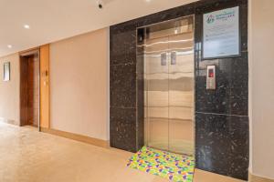 a elevator with a colorful floor in a lobby at Treebo Premium Cachet Suites in Coimbatore +27 photos
