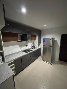 a kitchen with a stainless steel refrigerator in it at Omas Apartment in Abuja