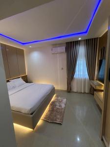 a bedroom with a bed with a blue led lighting at Omas Apartment in Abuja