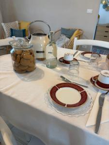 a table with plates and glasses on it at B&B Le Saline Bed & Breakfast in Cervia