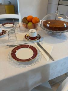 a table with plates and a cake on it at B&B Le Saline Bed & Breakfast in Cervia