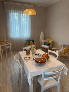 a dining room with a white table and chairs at B&B Le Saline Bed & Breakfast in Cervia