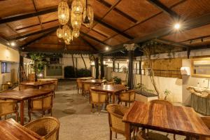 an empty restaurant with wooden tables and chairs at Hanu Reddy Residences, Poes Garden - Boutique Urban Retreat in Chennai