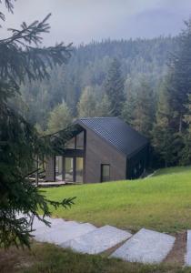 a house on a hill with trees in the background at Cottages Shepit Lisu New in Myta