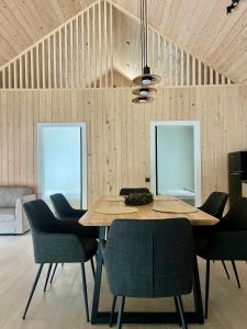 a dining room with a wooden table and chairs at Cottages Shepit Lisu New in Myta