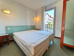 a bedroom with a bed and a large window at B4 Vue Montagnes Piscine in Souraïde