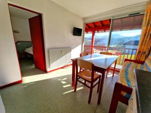 a room with a table and chairs and a balcony at B4 Vue Montagnes Piscine in Souraïde