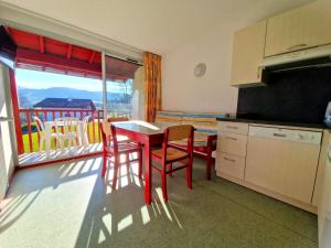 a kitchen with a table and chairs and a balcony at B4 Vue Montagnes Piscine in Souraïde