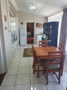 a kitchen and dining room with a wooden table and chairs at Philippolis - Reizigers Rust in Philippolis