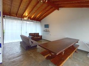 a living room with a wooden table and a couch at Edicula paixão in Muzambinho