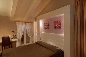 Postel nebo postele na pokoji v ubytování Hotel Arnolfo & Aqua Laetitia Spa & Beauty
