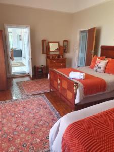 a bedroom with two beds and a dresser and a mirror at Philippolis - Reizigers Rust in Philippolis