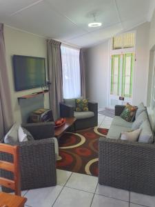 a living room with couches and a flat screen tv at Philippolis - Reizigers Rust in Philippolis