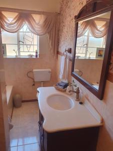 a bathroom with a sink and a mirror at Philippolis - Reizigers Rust in Philippolis +22 photos