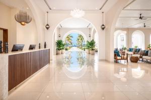 a lobby of a resort with a reception desk and a pool at Diamonds Bijoux in Bwejuu +28 photos