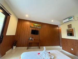 a bedroom with a bed with a wooden wall at Asri Sari Ubud Resort in Ubud