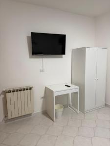 a white room with a desk and a tv on a wall at B&B Boffa in Buccino