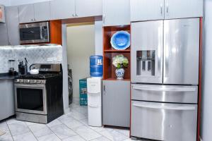 a kitchen with a stainless steel refrigerator and appliances at THE AFRICAN PALACE- Free Airport Pick up - High Speed Starlink WiFi - Car Rental in Tamale