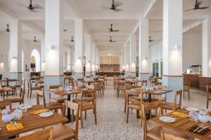 a dining room with wooden tables and chairs at Diamonds Bijoux in Bwejuu