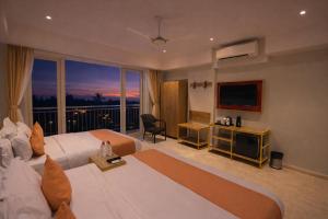 a hotel room with a large bed and a large window at Phoenix Unmatched Comfort - Hotel Near Fateh Sagar Lake Udaipur in Udaipur