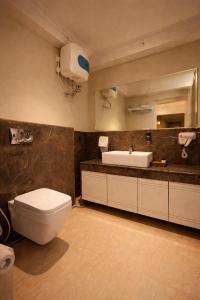 a bathroom with a white toilet and a sink at Phoenix Unmatched Comfort - Hotel Near Fateh Sagar Lake Udaipur in Udaipur