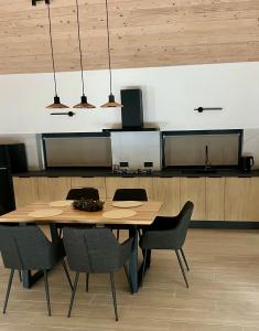 a dining room with a wooden table and chairs at Cottages Shepit Lisu New in Myta
