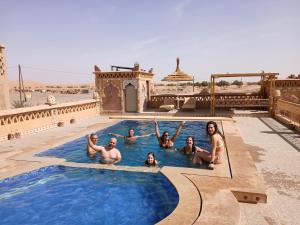 a group of people in a swimming pool at Riad Berber Merzouga in Merzouga