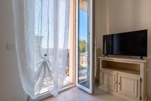 a living room with a large window and a tv at Maison di Andrea in Zibido San Giacomo +18 photos