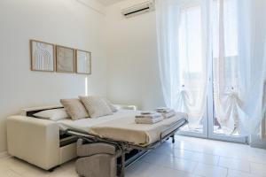 a white room with a bed and a window at Maison di Andrea in Zibido San Giacomo