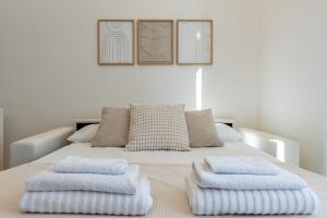 a white bed with three pillows on top of it at Maison di Andrea in Zibido San Giacomo