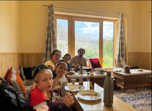 a group of people sitting at a table at ཨོཾ Homestay in Lāmayūrū