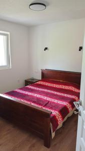 a bedroom with a bed with a red bedspread at Topli Kutak in Blatina