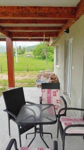 two chairs and a table on a porch with a swing at Topli Kutak in Blatina +13 photos