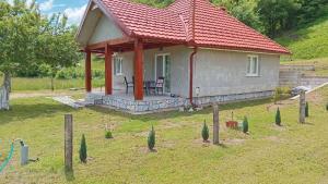 a small house with a red roof in a yard at Topli Kutak in Blatina