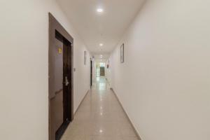 a hallway with white walls and a black door at Treebo Arya Palace With Swimming Pool in Dehradun