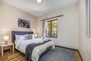 a bedroom with a bed and a window at Tashy Luxury 2 bedroomed apartment in Johannesburg