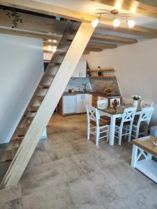 a kitchen and dining room with a wooden staircase in a loft at A frame Simić in Divčibare