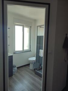 a bathroom with a toilet and a window at La Marie Galante Appart'Hotel in Saint-Georges-dʼOléron +19 photos