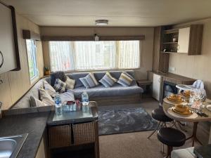 a living room with a couch and a table at TLJ Caravan Hires in Mablethorpe