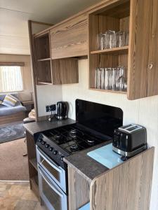 a kitchen with a stove and a toaster on a counter at TLJ Caravan Hires in Mablethorpe