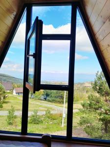 a window in a cabin looking out at a field at A frame Simić in Divčibare