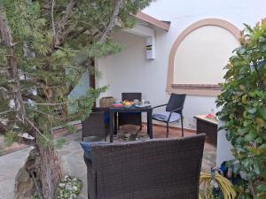 a patio with a table and chairs and an arbor at Casamare Roby in Tanaunella +27 photos