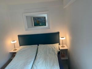 a bedroom with a bed with two lamps on both sides at Ferienwohnung Piesch in Glücksburg
