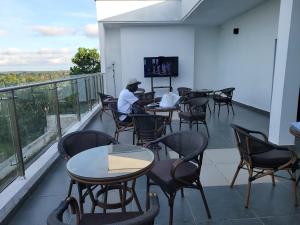 a man sitting at a table on a balcony at ADM HOTEL Grand-Lahou in Grand-Lahou