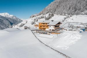 a lodge in the snow on a snow covered mountain at Bio & Reiterhof der Veitenhof - Pferde, Berge, Wellness & Freiheit im Ötztal in Niederthai